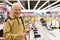 Elderly man examines tablet computer in showroom of electronics store