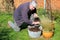 Elderly man filling container with compost.