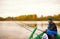 Elderly man fishing on a tranquil lake sits in wooden rod with his rod