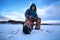 Elderly man fishing in the winter on the lake