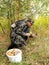 The elderly man gathers mushrooms in the wood focus on a bucket