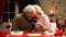 Elderly man giving jewelry gift box to his wife, woman tenderly kissing husband