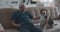 An elderly man with glasses is sitting on a sofa with his beagle dog. Communication of an elderly owner with a dog. The
