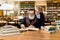 Elderly man grandfather and his granddaughter reading exciting book together in vintage old library, on the background