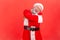 Elderly man with gray beard wearing santa claus costume hugging himself, feeling comfortable, narcissistic egoistic person, happy