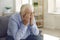 Elderly man, grieving about death of relative or forgotten by family, crying alone