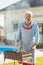 Elderly man grilling meat while having backyard barbecue party