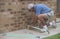 Elderly Man Hammering Nails And Wood.