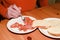 Elderly man holding fork and eating smoked salmon with slice of white bread. Solitude and single concept.