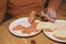 Elderly man holding fork and eating smoked salmon with slice of white bread. Solitude and single concept.