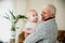 An elderly man holds his granddaughter. Happy grandfather with a little girl in his arms. End of self-isolation and meeting