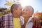 An elderly man kissing his wife