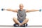 Elderly man lifting dumbbells and sitting on an exercise mat