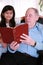 Elderly man and little girl reading Bible together