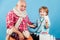 Elderly man and little kid doctor. Happy child and grandfather with stethoscope. Family playing in doctor and patient.