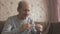 An elderly man measures the temperature with an old thermometer, a high temperature is a sign of the disease