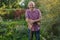 Elderly man with a mustache standing in the summer garden, smiling