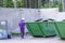 Elderly man, a pensioner  with a disabled cane looks in a trash can, looking for useful and necessary things for life. poverty.