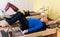 Elderly man performing pilates exercises on reformer during group workout