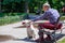 Elderly Man is Petting a White Pitbull Terrier Dog in the Park