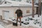 Elderly man with  plastic shovel stands in snowy yard