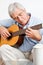 Elderly man playing guitar