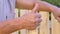 Elderly man raises wrinkled hand and makes a thumbs up gesture with finger, close up. Popular sign symbolizing OK