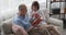 Elderly man reading a book to his wife drinking coffee