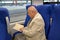 The elderly man reads the book in the electric train car