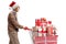 Elderly man with a santa claus hat pushing a shopping cart with christmas presents