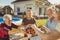 Elderly man serving food on a tray while having lunch with friends in the backyard