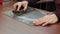 An elderly man sharpens a knife with a whetstone close-up