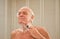 Elderly man shaving in front of a mirror