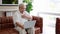 Elderly man sit on couch at home have online consultation on computer with doctor or physician talk on video call use webcam on