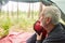 Elderly man sitting with backpack in camping tent