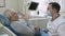 Elderly man sitting in dentist\'s chair talks about his dental problems to the doctor