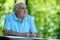 Elderly man sitting in the garden thinking