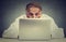 Elderly man sitting at table working on laptop computer