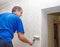 Elderly man smoothing the wallpaper with a roller