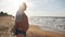 An elderly man stands on the seashore, watching the horizon. Active happy seniors concept