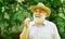 Elderly man in straw summer hat. Mental health. Peace of mind. Harmony of soul. Peaceful grandpa blowing dandelion