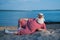 An elderly man in a striped retro swimsuit sunbathes on the beach. An old gray-haired bearded man in a hat lies on the