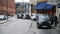 An elderly man in a suit gets into a waiting black London taxi cab outside King`s Cross St. Pancras Railway Station as younger