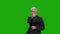 An elderly man in a suit scrolls through a virtual screen on a green background. Chromakey.