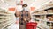 Elderly man in a supermarket wearing a protective mask and showing thumbs up