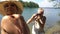 Elderly man taking picture of attractive senior woman with vintage camera on the beach.