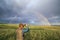 Elderly man taking pictures on a smartphone he is a magnificent rainbow Above the steppe