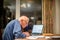 Elderly man using a laptop computer to check his finances ,Hampshire,England,U.K