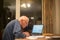 Elderly man using a laptop computer to check his finances ,Hampshire,England,U.K