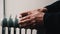 An elderly man warms his hands over an electric heater